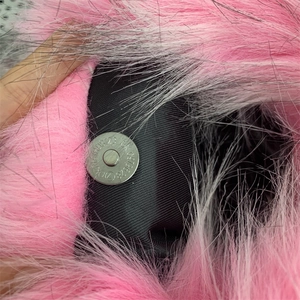 Detail of silver magnetic buckle on pink and white faux fur y2k handbag interior