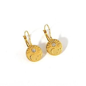 Detail of 18K gold-plated leverback earrings with celestial sun and moon relief charms