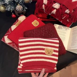 Close-up of bohemian knit shawl with red and white stripes and cute bear embroidery patch