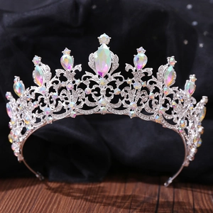 Detail of baroque crown with AB rainbow rhinestones on a textured black mesh and wood background