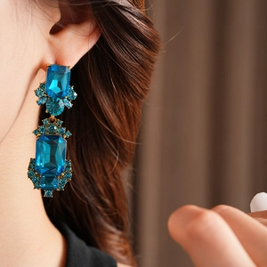 Detail shot of vintage geometric square blue gemstone earrings with golden metal setting