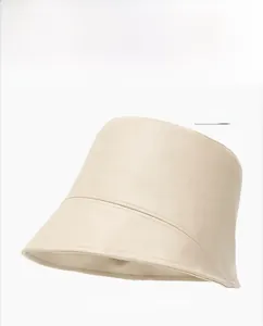 Close-up of beige PU leather bucket hat featuring quilted stitching details and soft texture
