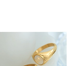Close-up of a minimalist gold ring featuring a polished band and round shell inlay