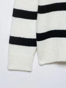 Close-up of black and white striped knit fabric showing thick texture and ribbed cuff detail