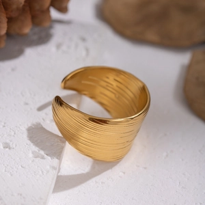 Brushed gold stainless steel wide open ring on stone base with natural styling