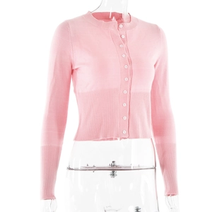 Close-up of pink knit cardigan showing white buttons and ribbed cuffs on sleeve and waist