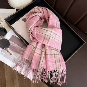 Gros plan d'une écharpe à carreaux rose et gris avec détails de franges