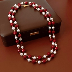 Detail of vintage double-layer necklace with red and pearl beads on leather box