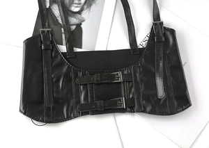 Detail of black PU leather corset harness belt with adjustable straps and double buckles