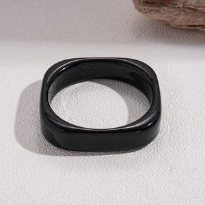 Detail of a thick black resin square bangle with a polished mirror-like gloss finish
