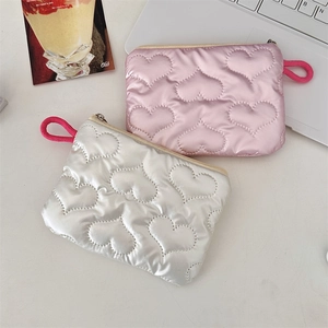 Detailed close-up of pink and white quilted heart-patterned pouches on a desktop