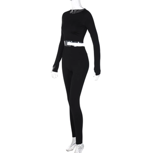 Detail of black long-sleeve crop top and high-waisted yoga leggings set on mannequin
