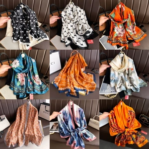 Close-up of various elegant silk scarves featuring floral and paisley patterns