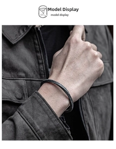 Close-up of men's dark Mobius bracelet with rugged rock texture on model wrist