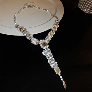 Macro shot of Y-shaped necklace with large rectangular crystals on a white plate