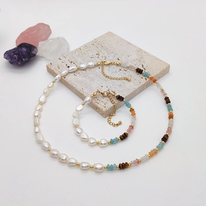 Detail of baroque pearl and amazonite beaded necklace and bracelet set on stone tray