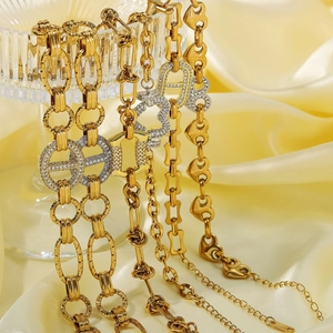 Detailed close-up of gold-plated heart links and geometric chains with micro-inlaid zircons