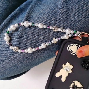 Detail of beaded pearl phone strap with floral charms on a 3D relief mobile case