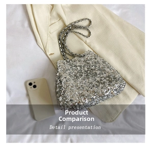 Detailed view of silver sequin bucket bag with metal chain strap next to a phone