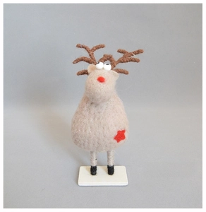 Macro shot of handmade wool felt reindeer decoration with red star details and knit antlers