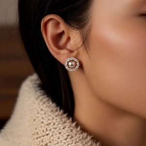 Close-up of 14k gold plated pearl flower stud earring on ear with zircon details