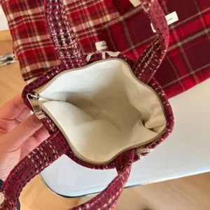Vue de dessus de l'intérieur du cabas en laine à carreaux rouges avec doublure crème