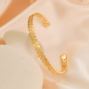 Elegant 18k gold plated stainless steel leaf motif open bangle on silk background