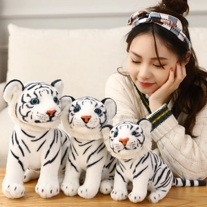 Drie maten witte tijger knuffels getoond met een model om de schaal en zachte textuur te tonen