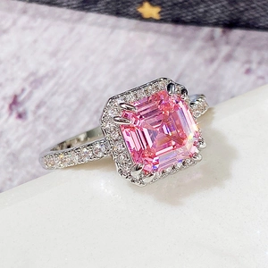 Luxurious square pink princess cut ring with halo diamonds on white marble base