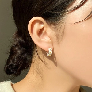 Minimalist 925 sterling silver daisy hoop earrings shown on a model for a stylish look