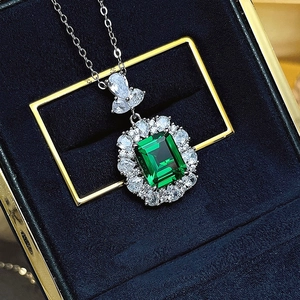 Silver necklace with emerald-cut green gemstone in luxury blue jewelry gift box