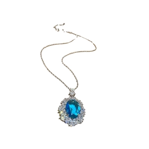 Silver necklace with blue oval zircon flower pendant and glittering crystals on white background