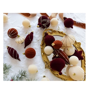 Close-up of velvet flocked Christmas balls in deep burgundy and caramel on a pine branch