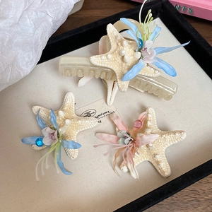 Detail view of starfish and fabric flower hair clips set for seaside vacation accessories