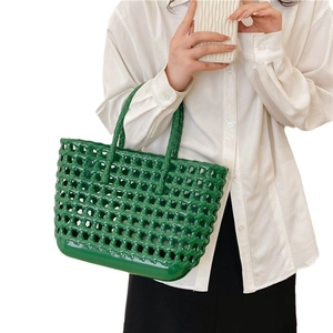 Green hollow woven jelly basket bag for summer beach travel with large capacity held by model