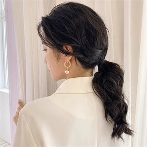 Vintage gold hoop earrings with large pearl drop shown on model for a luxury look