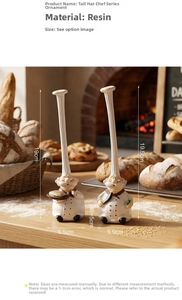Detail of resin chef figurines with tall white hats in a bakery scene with warm lighting