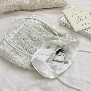 Detail of light green velvet lace shoulder bag with magnetic buckle and slim straps