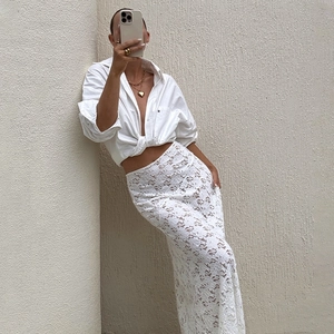 Women's summer high waist white lace midi skirt paired with tied shirt and gold jewelry