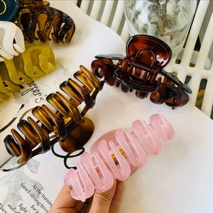 Close-up of matte and glossy large hair claws arranged on a fashion magazine
