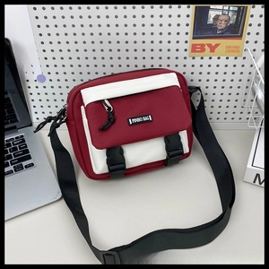 Close-up of vintage dark red and white canvas messenger bag with dual plastic buckles
