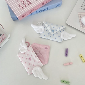 Detailed view of pastel wing coin purses with star patterns and plush wing decorations