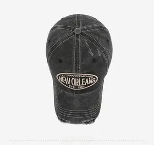 Close-up of vintage washed grey baseball cap with embroidery and distressed hole details