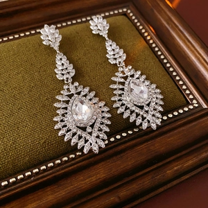 Detail view of silver wheat pearl drop earrings with sparkling crystals on velvet