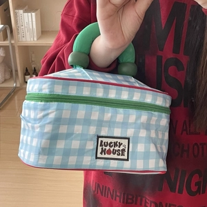 Blue and white checkered large cosmetic bag with green handle and Lucky House patch