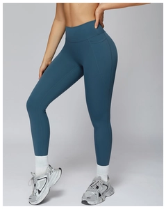 Detail shot of high-waisted yoga leggings in cyan featuring curved functional seams