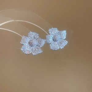 Macro view of five-petal flower stud earrings with sparkling pavé cubic zirconia