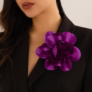 Elegant purple silk flower brooch and hair clip worn on a black suit lapel for women