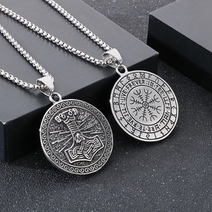 Detail of silver Viking Mjolnir and Vegvisir compass pendants on stainless steel chains