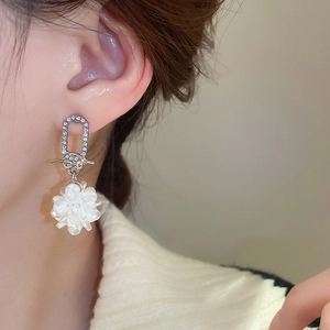 Nahaufnahme eleganter Blumen-Perlenohrringe mit Diamant-Akzenten am Model